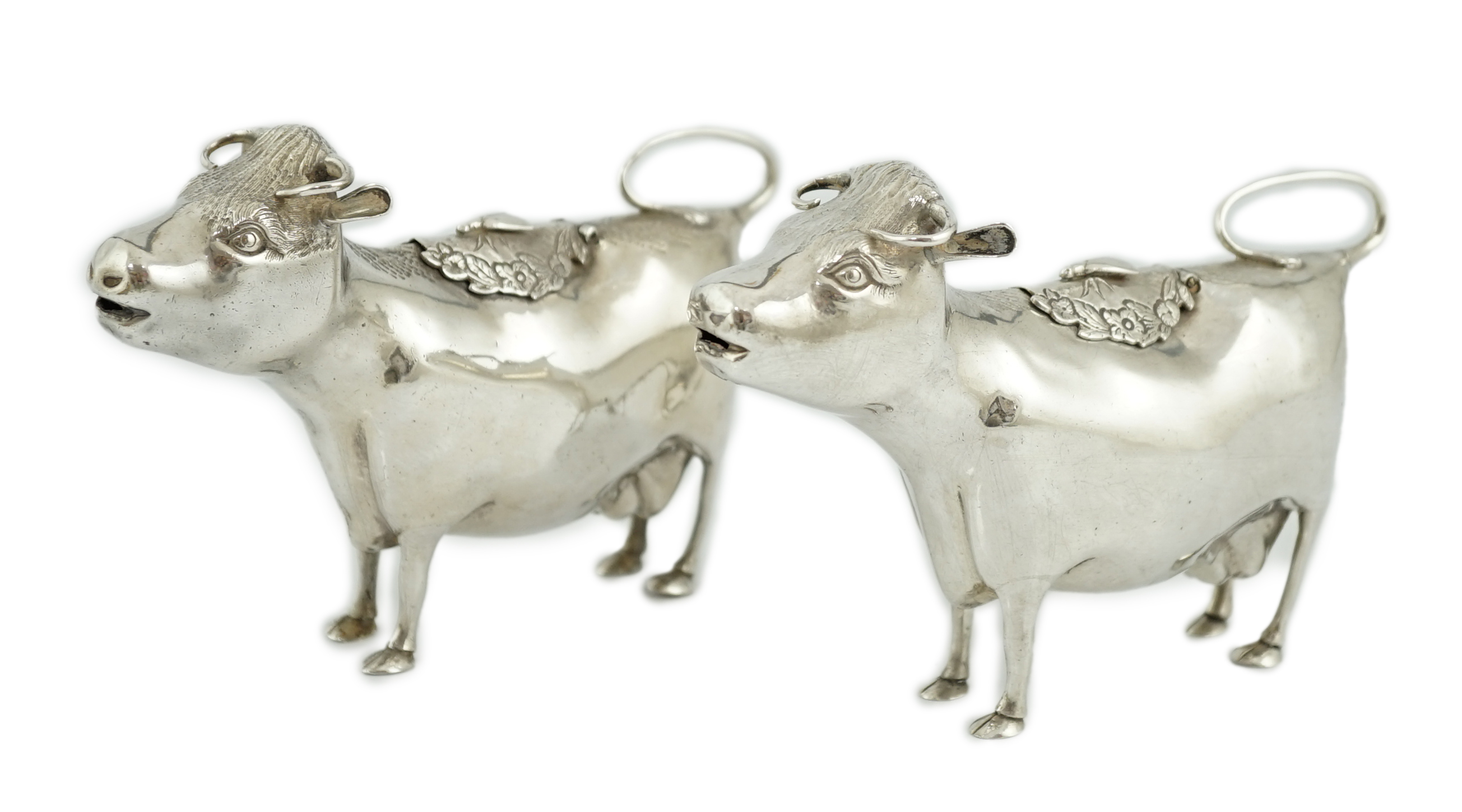 A pair of Elizabeth II silver cow creamers, by Heming & Co